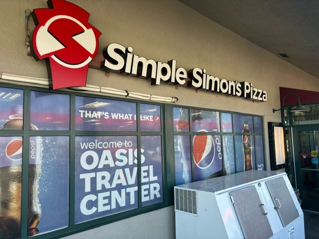 Image of pizza shop with a Simple Simon's Pizza sign on top