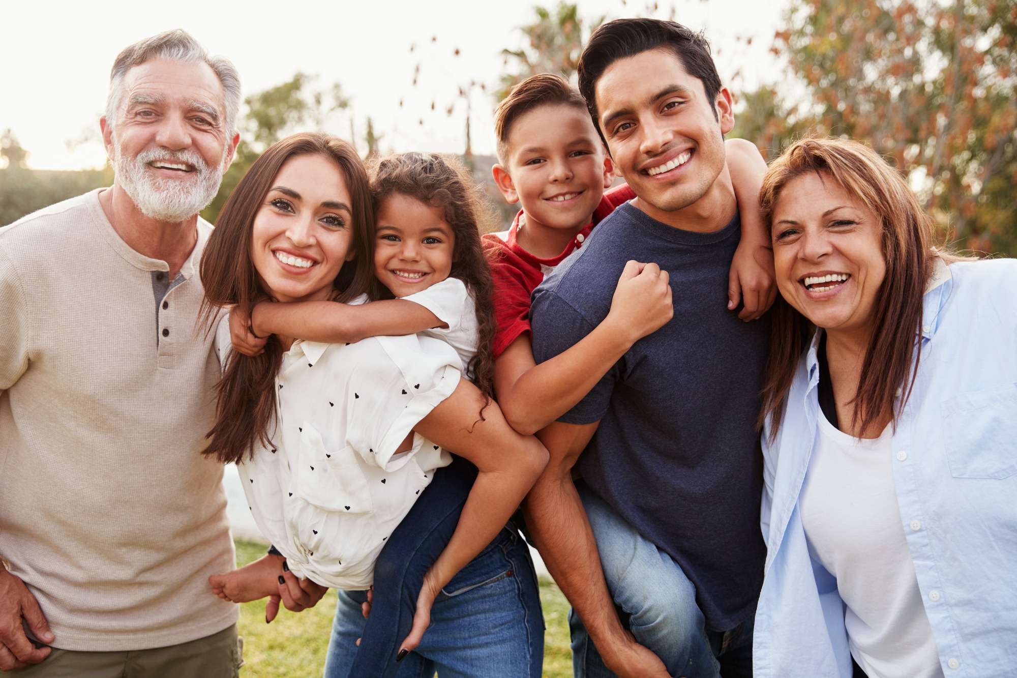 Three generation Hispanic family standing in the park